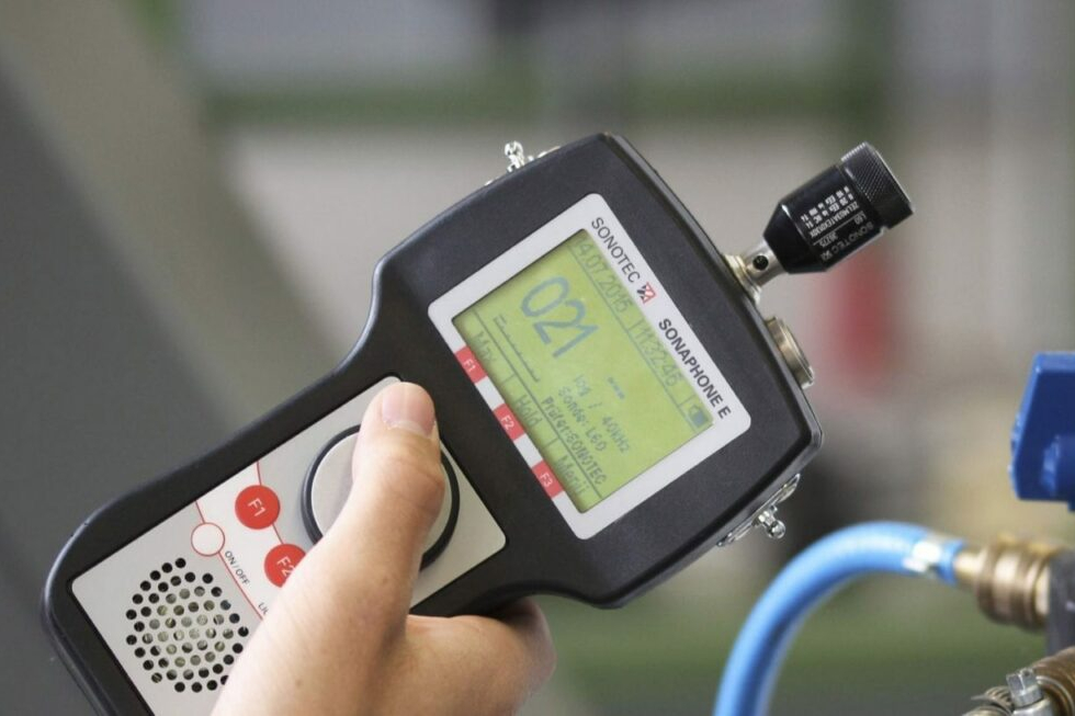 Ultrasonic leak detector with digital screen and displaying readings while held near hose