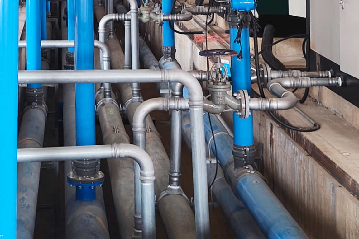 crisscrossed piping network below and above flooring with different pipe sizes and materials